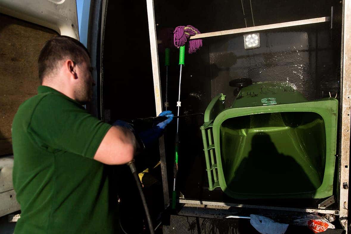 Bins, A man cleaning the exterior of a green truck.